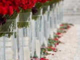 red roses in tall vases and red rose petals to decorate the aisle and line it up to make it look gorgeous and very romantic