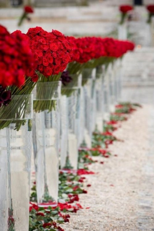 red roses in tall vases and red rose petals to decorate the aisle and line it up to make it look gorgeous and very romantic