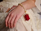 a creative pearl and faux red rose bracelet is a beautiful and romantic accessory for a Valentine’s Day vintage bride