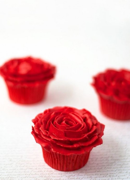 red cupcakes with red frosting that forms a rose on top are lovely for a Valentine's Day wedding