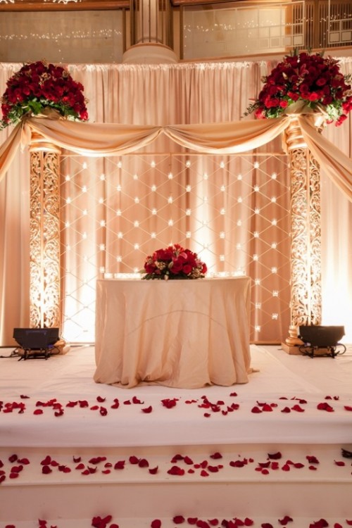 lush red rose arrangements on the table and over it for a beautiful and very refined Valentine's Day wedding look