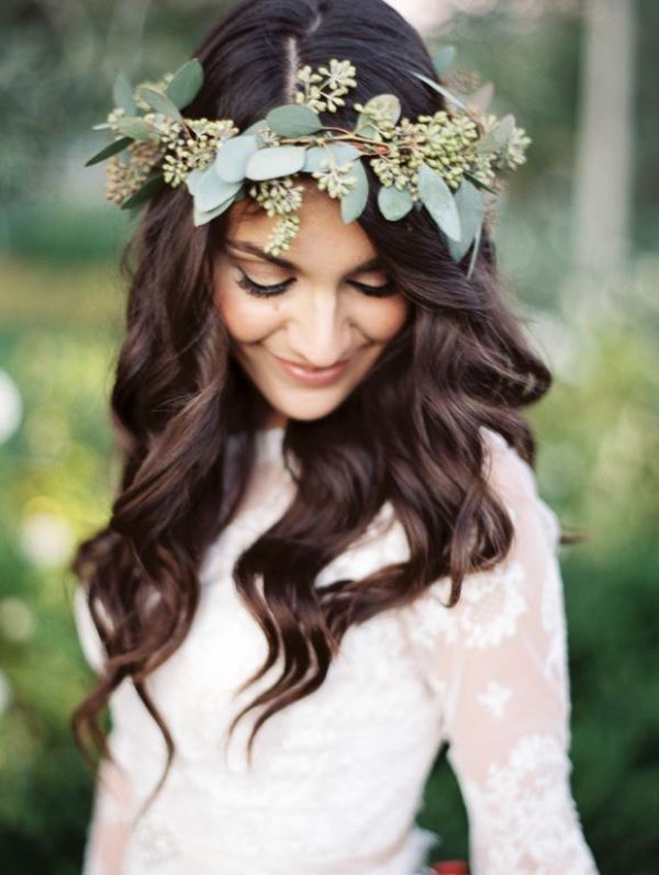 The bride wearing a neutral lace wedding dress and a green leafy crown for a boho chic look