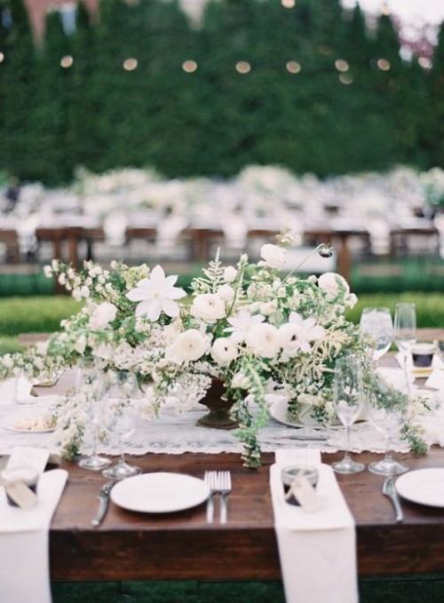 a beautiful and large textural wedding centerpiece of greenery and white blooms is a chic idea for a spring or summer wedding