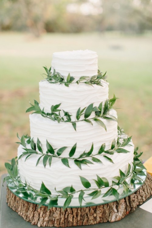 a white textural buttercream wedding cake decorated with greenery is a cool idea for every neutral wedding