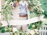 a giant greenery and white bloom wreath can be a nice decoration for a spring or summer wedding