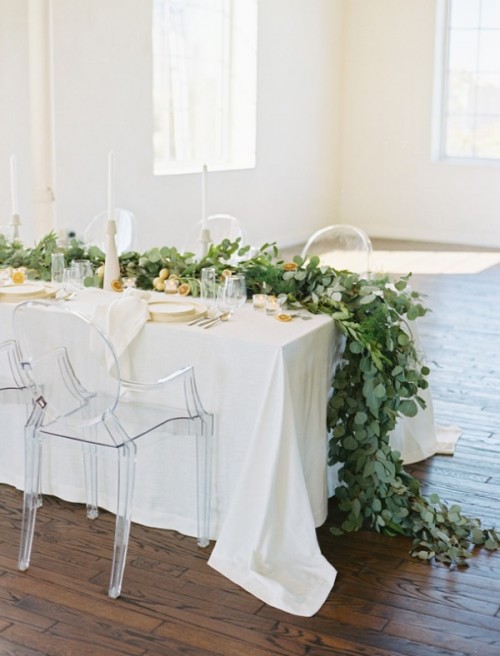 a chic wedding tablescape with greenery table runners, citrus, gilded touches and a neutral tablecloth