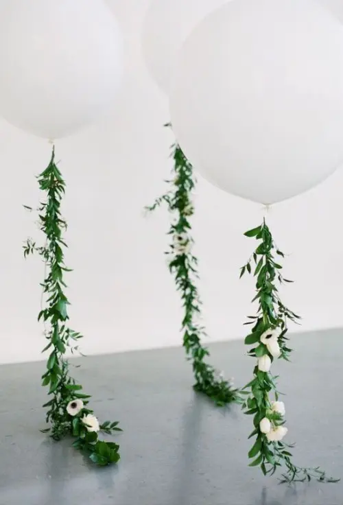 giant white balloons with greenery and white blooms are amazing for modern wedding decor