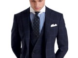 a sophisticated checked navy groom’s suit, a blue and white striped shirt, a navy and blue polka dot tie for a refined look