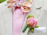 a bright groom’s look with a pink checked shirt, a neutral striped blazer and a super bold printed bow tie plus a pink boutonniere