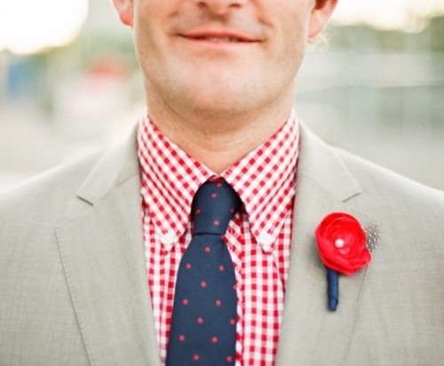 a modern groom's look with a red boutonniere and a checked red shirt