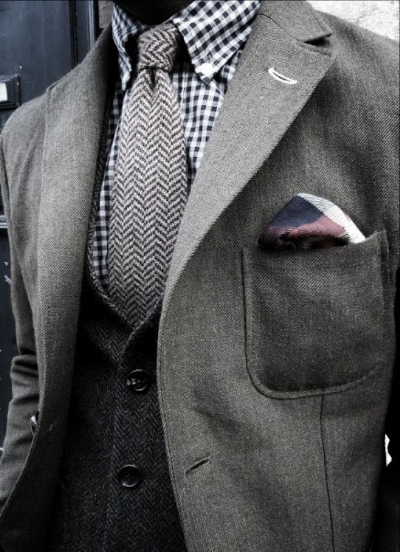 a grey groom's look with a black and white checked shirt, a grey tie, a waistcoat and a fitting blazer for an elegant groom's look at the wedding