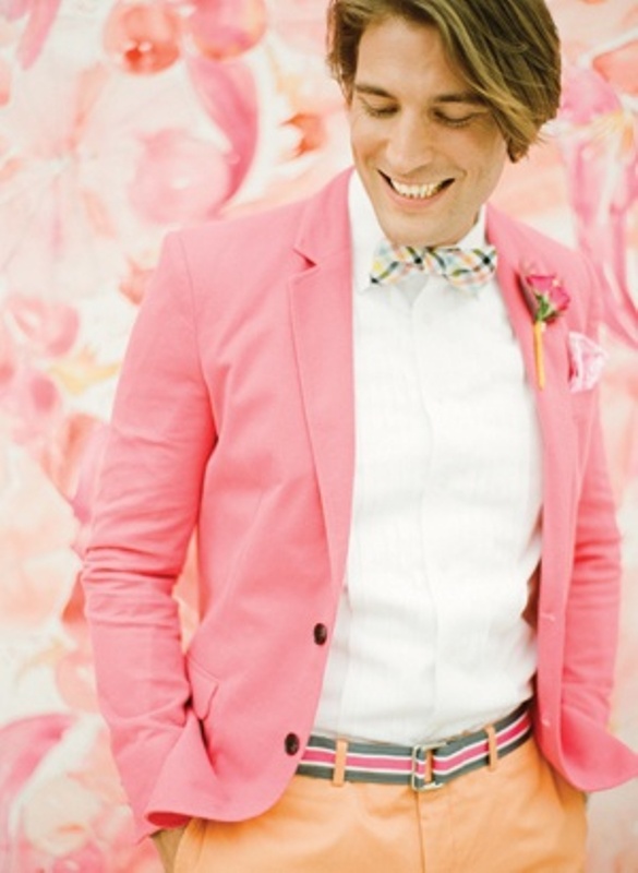 a bright groom's outfit with a white shirt, a pink blazer, a bright checked bow tie and a bright striped belt is amazing