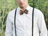 a bold groom’s look with black pants, a white shirt, blakc thin supenders and a bold printed bow tie