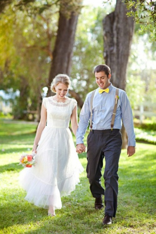 a rustic vintage groom's look with a light blue shirt, a yellow bow tie, grey pants and neutral suspenders