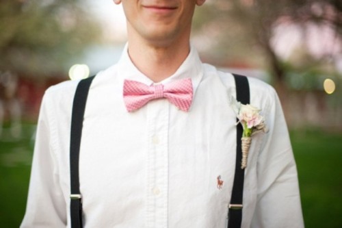 a white shirt, black suspenders, a pink bow tie and a blush floral boutonniere for an elegant summer groom's look