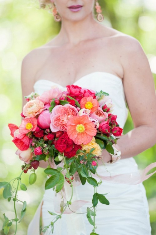 a gorgeous summer wedding bouquet with pink and coral roses, pink and blush peony roses and greenery and some strawberries is a great idea for summer