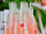 strawberry lemonade in bottles with fresh berries inside is amazing for serving it at a spring or summer wedding