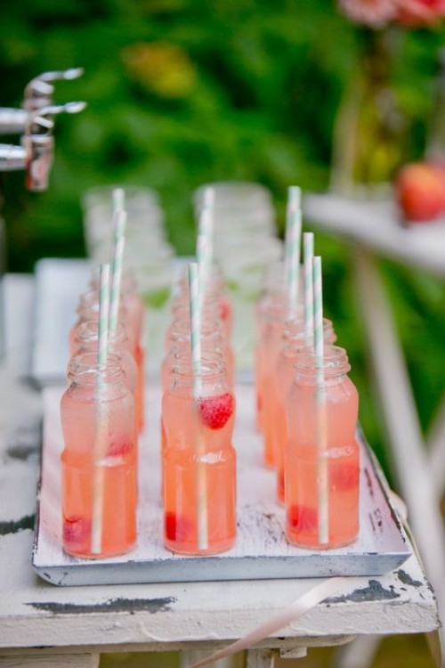 strawberry lemonade in bottles with fresh berries inside is amazing for serving it at a spring or summer wedding