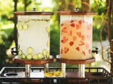 a drink station with cucumber and strawberry lemonade and glasses is a stylish and cool idea for a summer wedding
