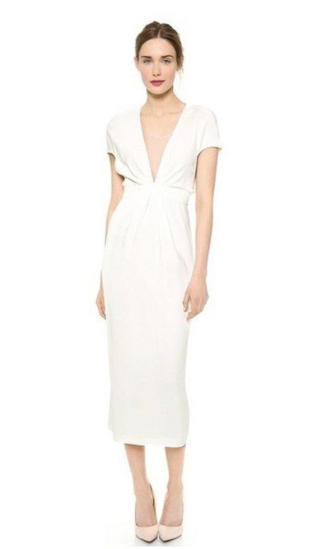 a white plain semi-fitting midi dress with short sleeves and a covered plunging neckline plus white heels is an elegant solution for a minimalist bride-to-be