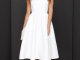 a white sleeveless A-line midi dress of plain fabric, nude heels and a white clutch for a chic modern or minimalist bride-to-be look