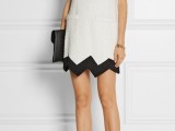 a white A-line mini dress with a high neckline and short sleeves, a black geometric rim, black and white shoes and a black clutch for a modern wedding