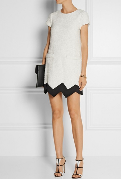 a white A-line mini dress with a high neckline and short sleeves, a black geometric rim, black and white shoes and a black clutch for a modern wedding