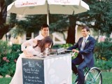 a modern ice cream trolley with a bike and an umbrella plus a chalkboard menu attached to its side is a lovely idea for a modern wedding