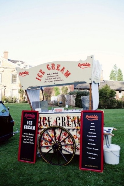 a vintage ice cream trolley with chalkboard signs and a sign over it, with a large wheel is a stylish idea for a vintage inspired wedding
