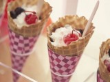 a clear acrylic stand holding ice cream cones, with ice cream and cherries is a lovely idea for a modern wedding, wrap the cones with some pretty paper
