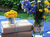 books wrapped in kraft paper, a candle and some bright blooms in jars wrapped with twine