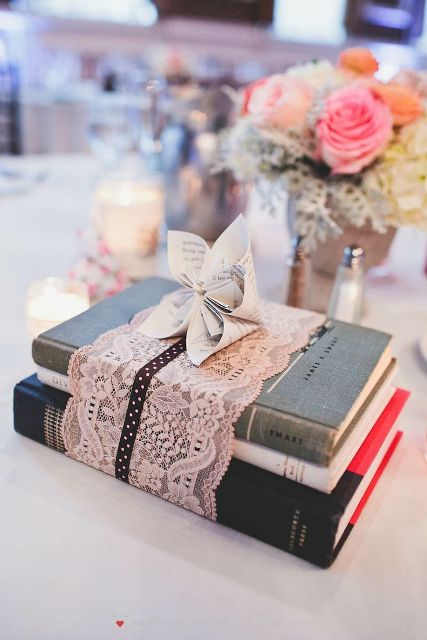 a vintage book wedding centerpiece - s stack wrapped with lace and with a paper bloom