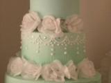 a bold mint green wedding cake with white sugar blooms and edible beads is a stylish idea