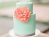 a stylish mint green wedding cake with a copper touch, white shards on top and a coral sugar bloom
