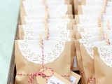 kraft paper bags topped with doilies, with twine and tags are great to pack your wedding favors, they look nice and are budget-friendly