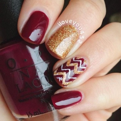 burgundy nails with gold glitter accents and a bold chevron nail for a more outstanding look