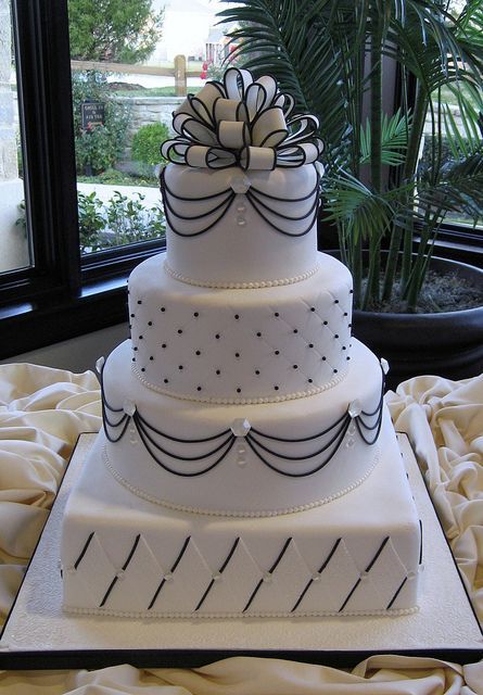 a refined and chic black and white wedding cake with crystals and a large bow on top is a fantastic idea for a vintage-inspired chic wedding