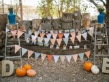 a rustic wedding decoration of two ladders, colorful buntings, family photos and bright pumpkins for a fall feel