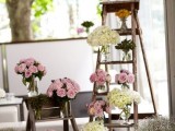 simple rustic wedding decor of wooden ladders and neutral and pink bloom arrangements in jars