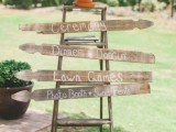 a rustic wedding sign of a ladder and some wooden planks plus a succulent on top is a cool idea for a rustic wedding