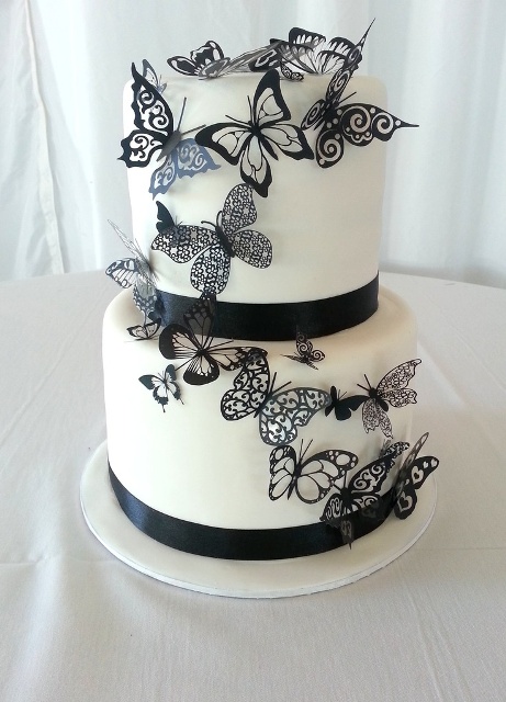 a black and white wedding cake with ribbons and butterflies is a fresh take on classics with a refined feel