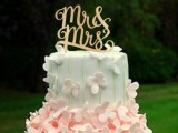 a white, pink and green wedding cake decorated with pink sugar butterflies and a gold calligraphy topper is a refined and charming idea of a summer wedding cake