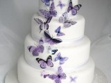 a white wedding cake with ribbons and purple and lilac bitterflies looks very tender, soft and ethereal, it’s real charm and love