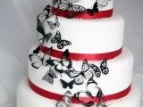 a white wedding cake with red ribbons and black lacey butterflies is a bold and very unusual idea to go for, it looks chic and bold