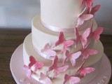 a white wedding cake with ribbons and pink sugar butterflies is a chic and stylish idea for a romantic wedding