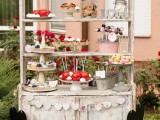 a beautiful vintage-inspired candy bar made of a whitewashed buffet, paper banners and hearts and with vintage bowls and stands