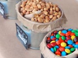 a stylish rustic candy bar done with kraft paper, metal buckets with kraft paper and candies plus chalkboard markers on them
