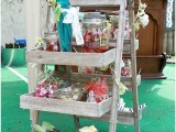 a mini rustic candy bar done with an easel and lots of box shelves to serve candies