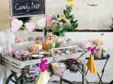 a vintage-inspired candy bar with a rustic cart, paper fans, a chalkboard sign and a heart banner