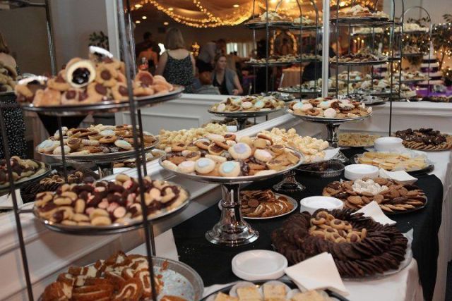 a large cookie table with metal stands and large plates plus plates for putting sweets on them